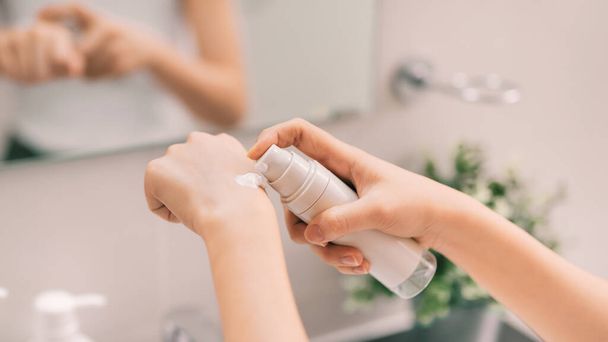 Žena pečující o svou pokožku a pomocí hydratační a vyživující krém na ruce po koupeli doma. Produkt péče o pleť - Fotografie, Obrázek