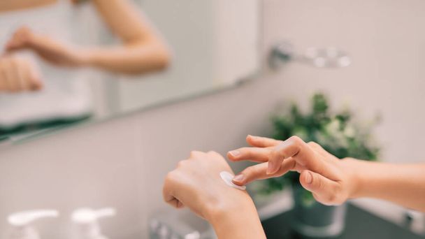 Testgondozás. Nő alkalmazása hidratáló kézkrém kézre és körmökre zuhany után. - Fotó, kép