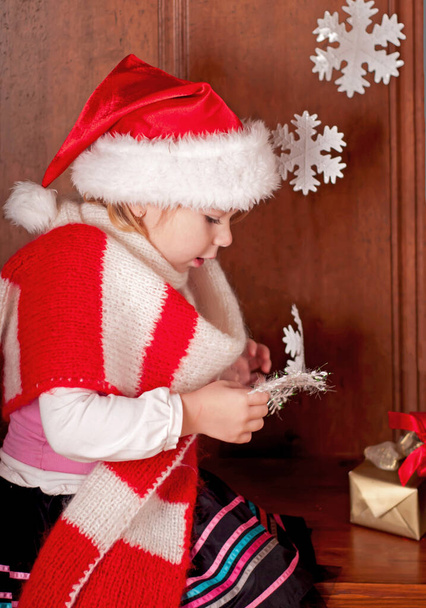 child in a suit of Santa Claus in the room decorated to new year - 写真・画像