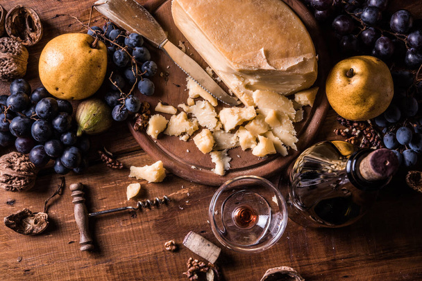 Käse, Trauben und Nüsse auf Holztisch - Foto, Bild