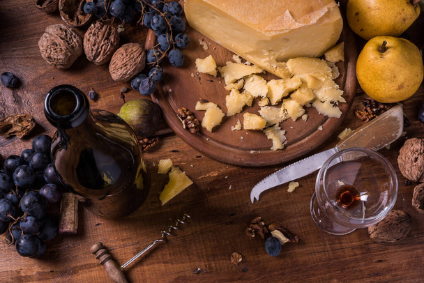 Käse, Trauben und Nüsse auf Holztisch - Foto, Bild