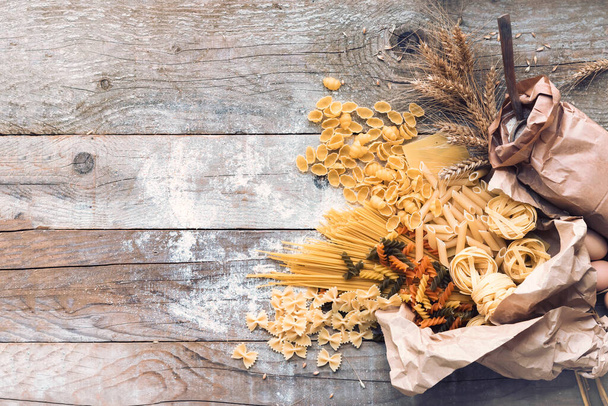 Various mix of pasta on wooden rustic background - Фото, зображення