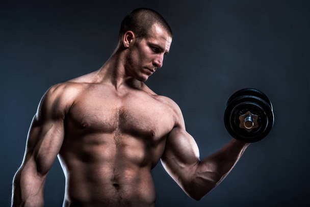 muscular man with dumbbells on black background  - Photo, Image
