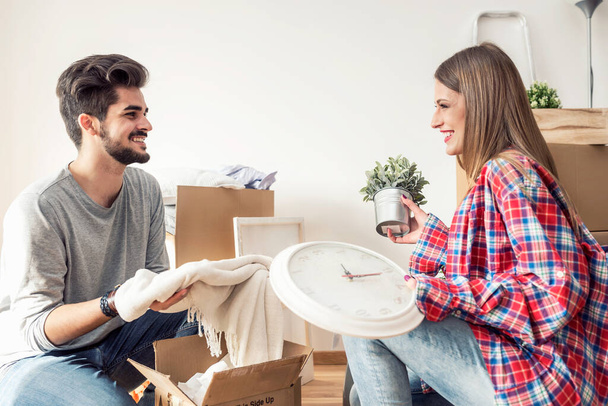 Young couple unpacking cardboard boxes at new home - 写真・画像