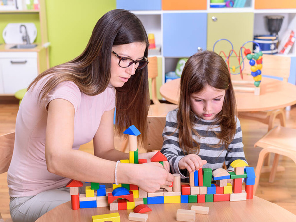 učitel a dívka hrát s hračkou bloky ve škole - Fotografie, Obrázek