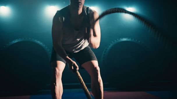 Fitness athlete training using battle ropes intense workout. - Foto, afbeelding