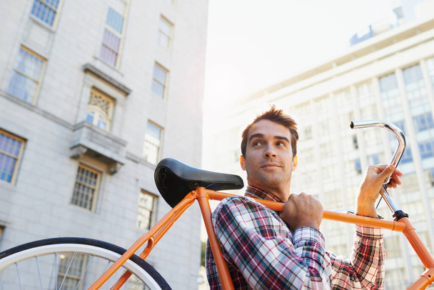 Reisen auf trendige Weise. ein gutaussehender Mann, der mit dem Fahrrad in der Stadt unterwegs ist - Foto, Bild
