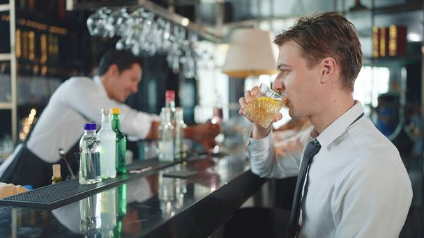 Businessman drinking whiskey in restaurant. Successful boss spending time in place with expensive alcohol - Foto, afbeelding