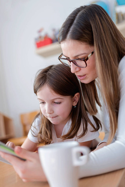 Madre e bambino con tablet in casa a giocare e imparare - Foto, immagini