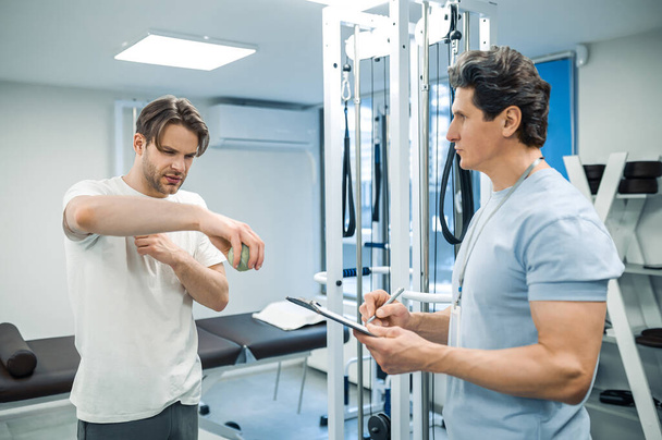 Physical therapy. Male patient have a physical therapy session in rehabilitation center - Valokuva, kuva