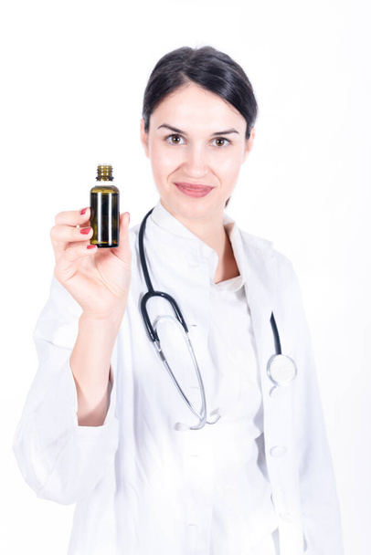 beautiful young woman with a stethoscope and a bottle  - Photo, Image