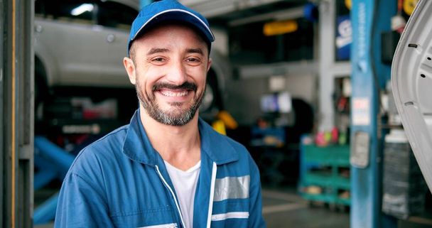 Visage souriant d'homme caucasien mécanicien de voiture debout regardant la caméra à autocar - Photo, image
