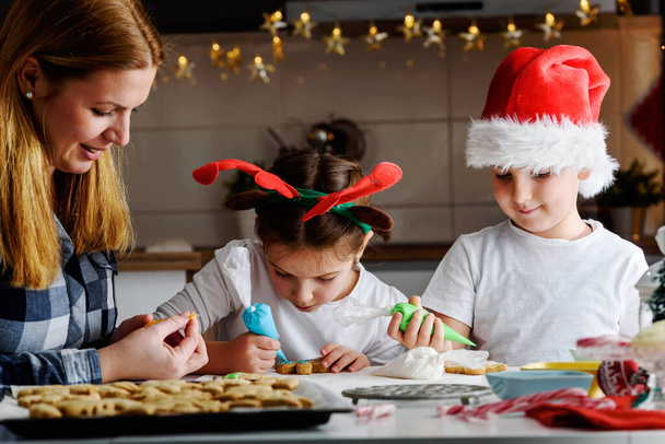 Mãe com crianças fazendo biscoitos para o Natal - Foto, Imagem