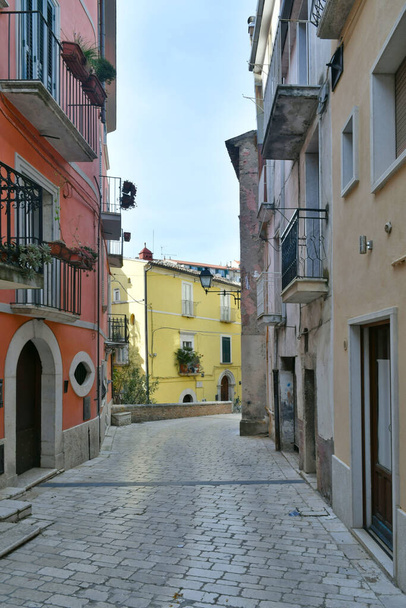 Een smalle straat tussen de oude huizen van Guardia Sanframondi, een klein stadje in de provincie Benevento, Italië. - Foto, afbeelding