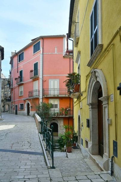 Ένας στενός δρόμος ανάμεσα στα παλιά σπίτια της Guardia Sanframondi, μια μικρή πόλη της επαρχίας Benevento, Ιταλία. - Φωτογραφία, εικόνα