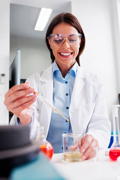 γυναίκα επιστήμονας στο εργαστήριο κάνει χημικές δοκιμές - Φωτογραφία, εικόνα