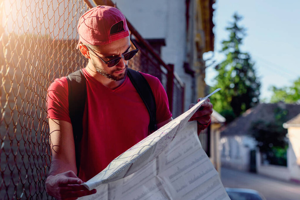 Fiatal városi hipster utazó látszó térkép szabadban - Fotó, kép