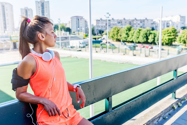 Sportos városi kocogó lány áll a szabadban pihenés edzés után - Fotó, kép