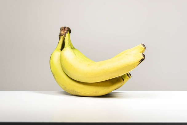 Um bando de bananas maduras numa superfície branca - Foto, Imagem