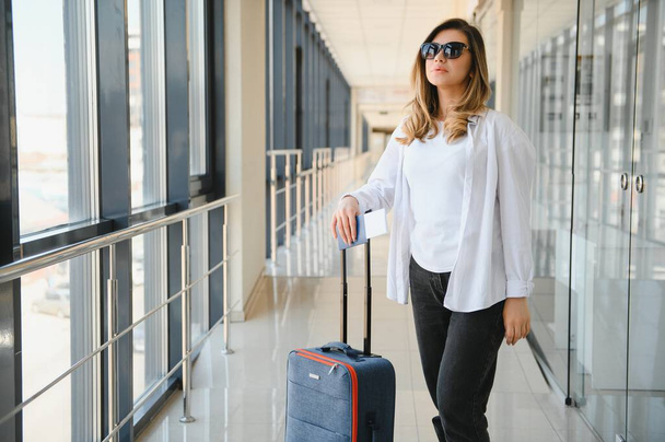 Happy woman traveling and walking in airport. - Foto, Imagen