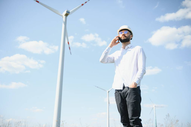 Engineer is checking energy production on wind turbine. Worker in windmills park. - Foto, Imagem
