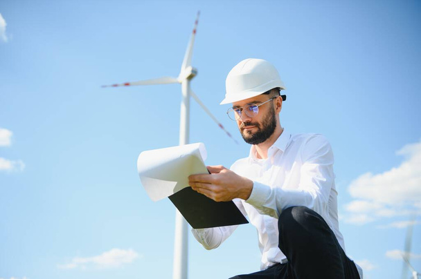 Windmill turbine maintenance engineer standing at wind farm - Foto, Imagem