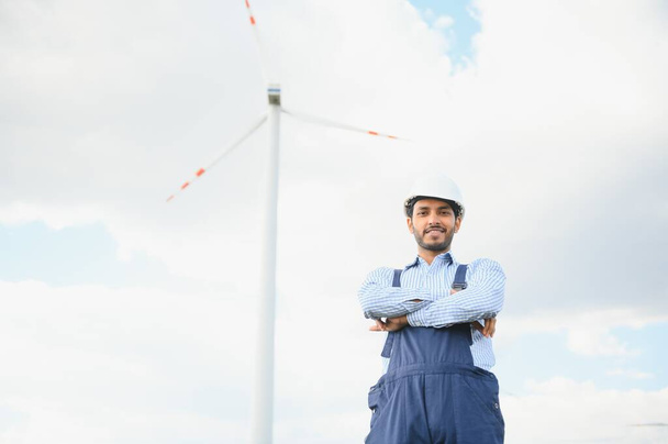 India engineer at windmill farm operation to generate electricity, Asian man working at wind turbine farm, Clean and green energy - Fotografie, Obrázek