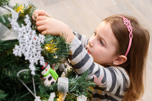 Belle petite fille décorant arbre de Noël
 - Photo, image