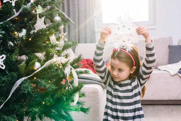 beautiful little girl decorating christmas tree - Photo, Image