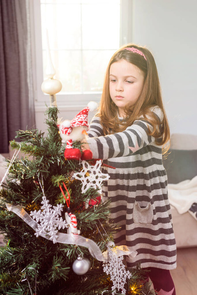 Hermosa niña decorando el árbol de Navidad
 - Foto, imagen