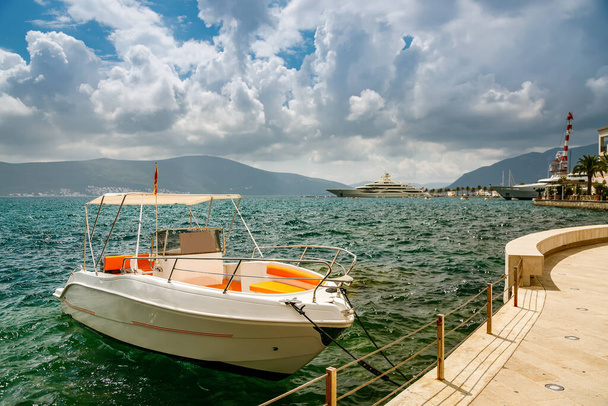 Przylądek morski z nabrzeża Tivat z małą łodzią widokową do wynajęcia, Czarnogóra - Zdjęcie, obraz