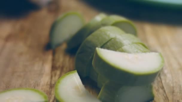 Der Koch schneidet die Zucchini in sehr angenehmer Atmosphäre. 4k-Kinematographie-Videorezept. - Filmmaterial, Video