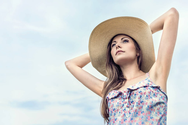 beautiful woma in  straw hat posing in a summer day. - 写真・画像
