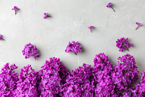 Složení květin. Jarní fialové květy šeříku na šedém betonovém pozadí. Ležel. Horní pohled. Svatební nebo výroční přání - Fotografie, Obrázek