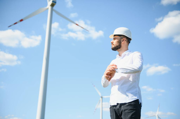Engineer in field checking on turbine production. - Photo, image