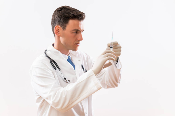 Image of young  doctor with injection. - Фото, изображение