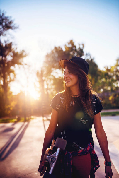 Menina urbana bonito segurando longboard no parque de skate - Foto, Imagem