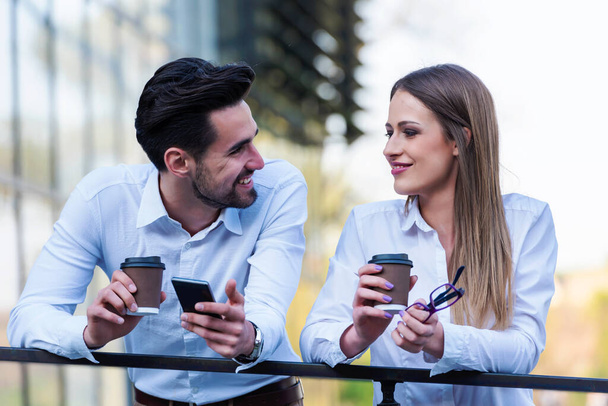 Smiling business couple outdoors in the street on coffee brake - Foto, Imagem