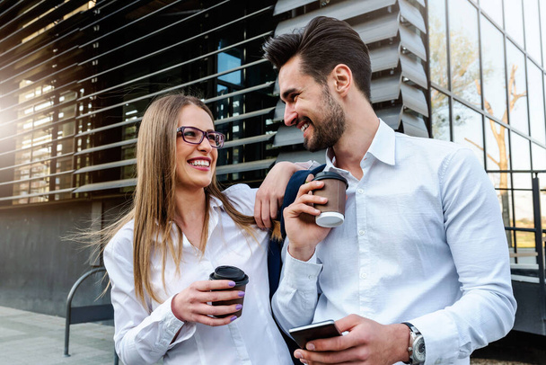 Smiling business couple outdoors in the street on coffee brake - Foto, imagen