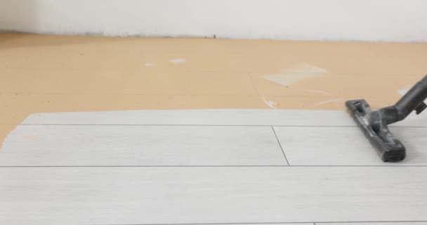 Aspirapolvere striscia pulita sul pavimento in legno polveroso. Casa pulita e servizi di pulizia dopo la ristrutturazione - Filmati, video
