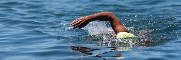 Profesionální triatlonista plavání plazit v oceánu, freestyle plazit se v oceánu. Plavec v čisté mořské vodě. Plavání pod širým nebem - Fotografie, Obrázek