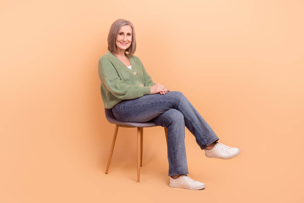 Full body photo of cozy sitting senior lady white hair new furniture chair promo billboard advertisement isolated on beige color background. - 写真・画像