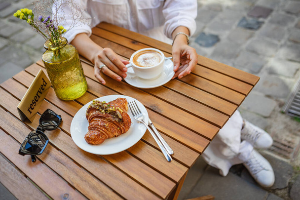 Breakfast on summer terrace with croissants and coffee - Фото, изображение