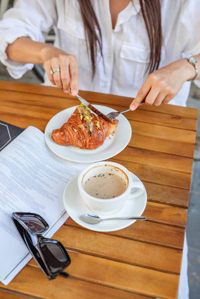 Breakfast time woman with croissant, coffee, and magazine - Valokuva, kuva