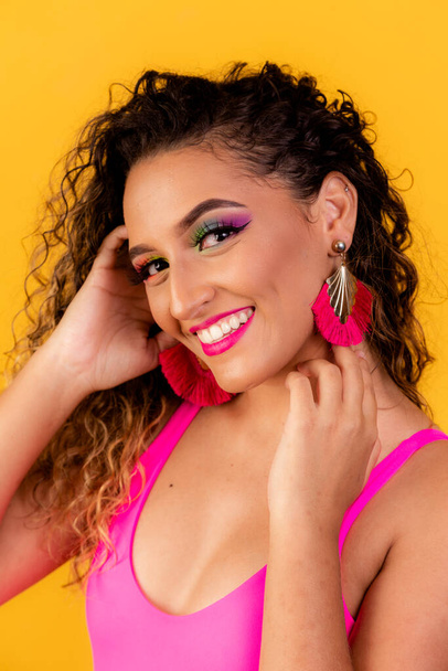 Beauty portrait of african american woman with afro hairstyle and glamour makeup. Brazilian woman. Mixed race. Curly hair. Hair style. Yellow background. Afro woman smiling at the camera - Photo, image