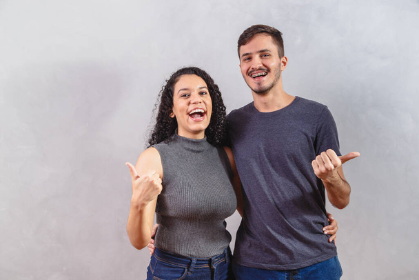 young couple making ok sign on grey background - Foto, afbeelding