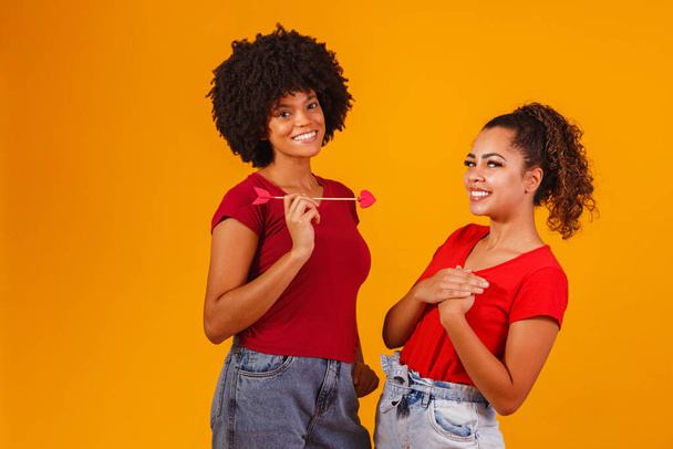 afro lesbian couple on yellow background. homo-affective couple - Foto, Imagen