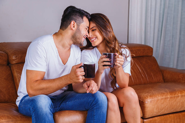 valentine couple drinking tea or hot chocolate on the sofa - Foto, afbeelding