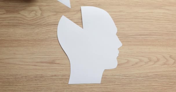 Weibliche Hand mit menschlichem Kopf und einem Stück Gehirn aus Papier. Neurologie und logisches Denken - Filmmaterial, Video