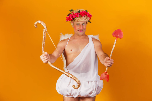 Valentine's day concept. Portrait of the God of love - Cupid with bow and arrow on a yellow background. - Foto, Bild